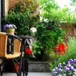 A lush container garden with herbs and flowers thriving on a small balcony.