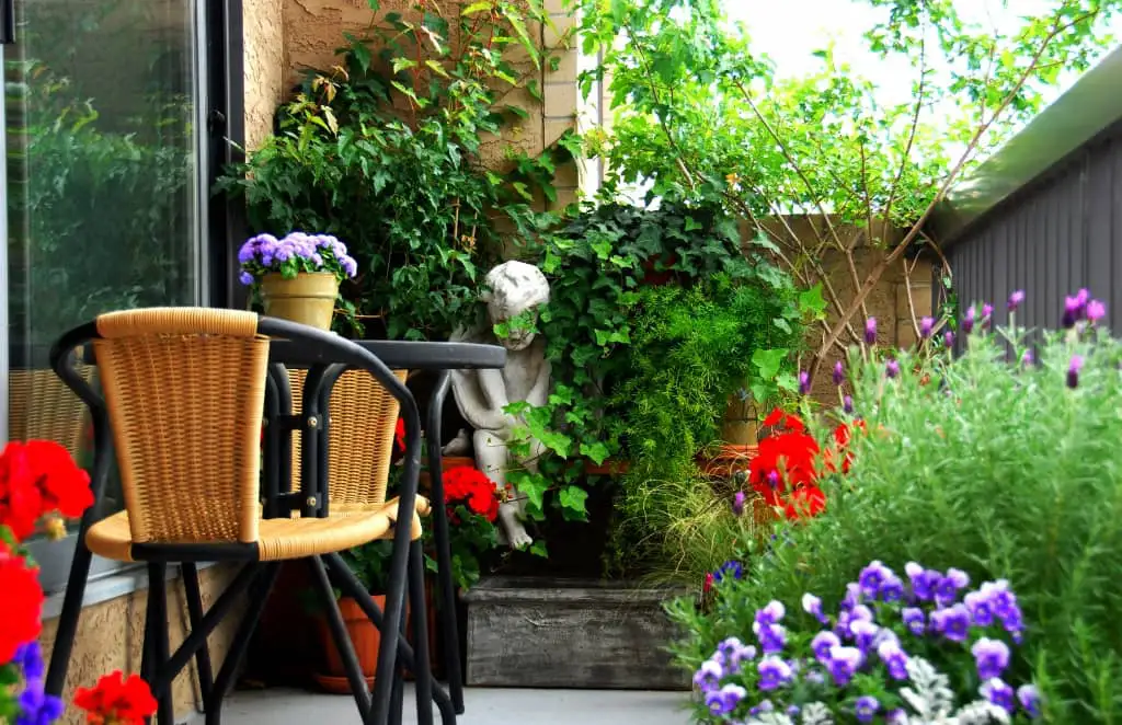 A lush container garden with herbs and flowers thriving on a small balcony.